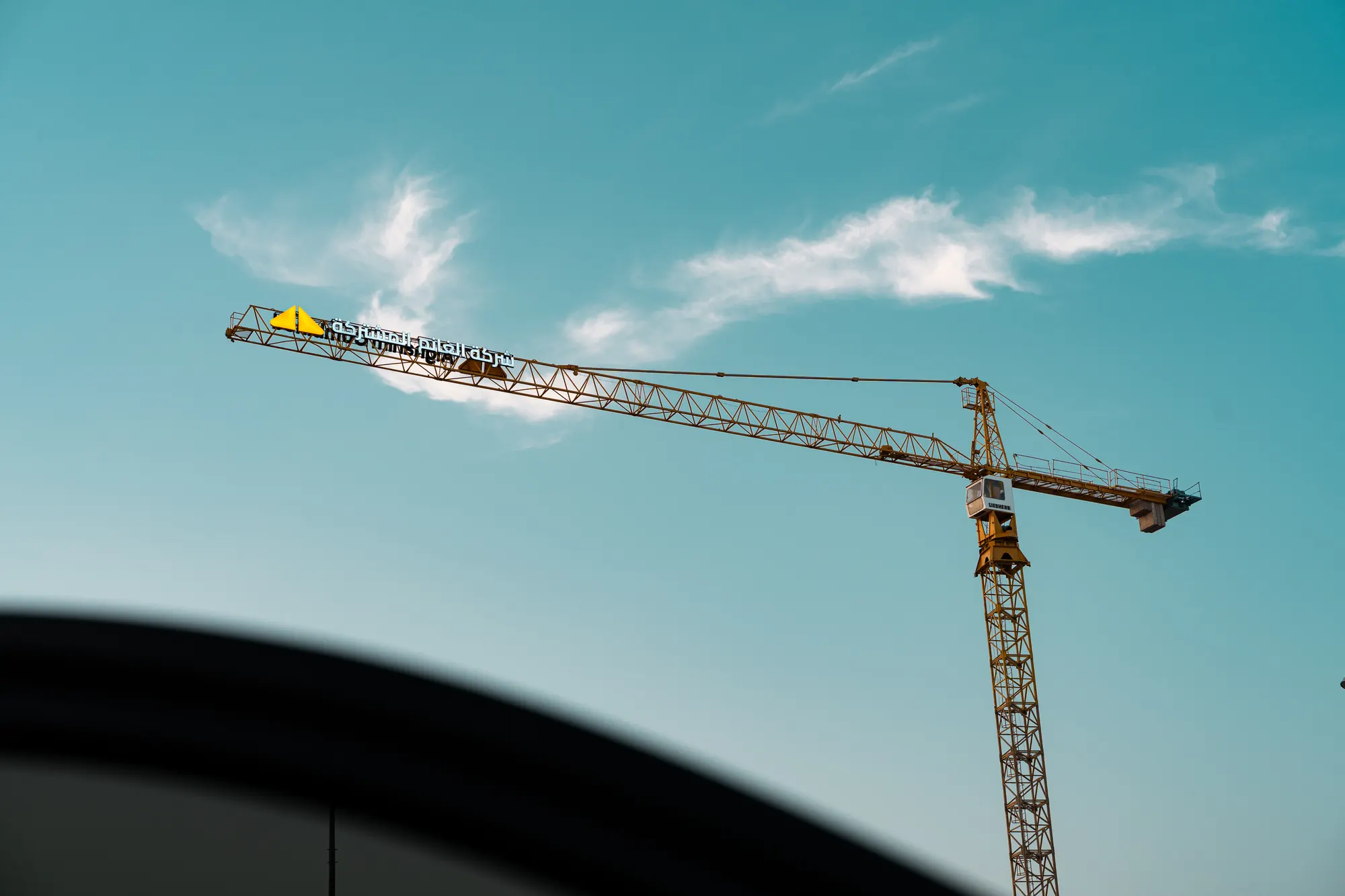 Alghanim Combined tower crane against a clear blue sky
